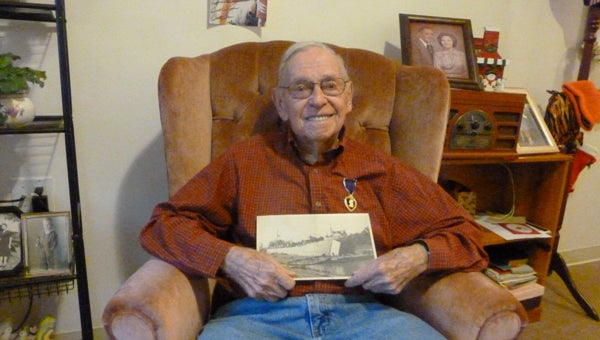 U.S. Navy veteran William "Bill" French, age 91, received a Purple Heart for injuries received during the sinking of LST 523 by a German mine during WWII. He was one of only 28 survivors.  French is shown in his room at Ridgeview at Meadowbrook wearing his Purple Heart and holding a picture of LST 139 that he served on during the remainder of the war. (Contributed)