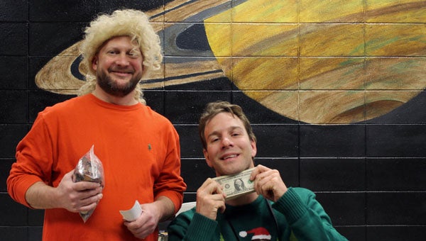 A wig-sporting Chris Cotter and a clean-shaven Ryan Dye, two PHS teachers who modeled positive stress-management with a United Way challenge during semester exams, show off their bounty just before presenting it to a local United Way representative. (Contributed)