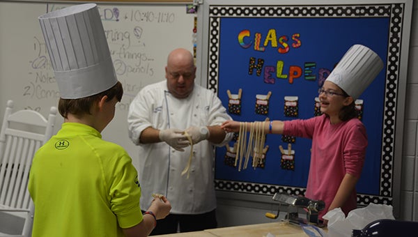 Executive Chef Joseph Sciarrotta has HIS students help him with a demonstration at Career Day on Friday, Jan. 22. (Reporter Photo/Graham Brooks) 