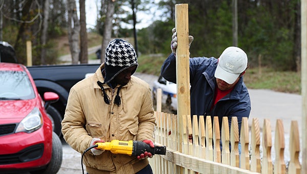 Volunteers work to build a new fence around the upcoming H.O.P.E. Mission Outreach center near the intersection of Simmsville Road and Fifth Avenue Southeast on Jan. 18. (Reporter Photo/Neal Wagner)