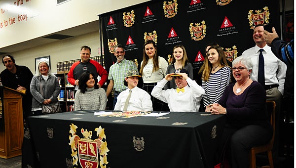 Thompson High School baseball players Jonathan Crawford, center left, and Riley Reach, center right, sign with Southern Union State Community College while surrounded by family members and friends during a Jan. 27 ceremony at THS. (Reporter Photo/Neal Wagner)