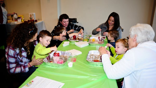 Children conduct an "apple volcanoes" experiment showing the chemical reaction between baking soda and water during the North Shelby Library's first preschool Kitchen Science program on Feb. 12. Pictured are, from left, Amber Padurean and her son Paxton; Betty Jaskolka and her son Sam; Julie Wehner and her son Jacob; and Nancy Richard with her granddaughter Jordan Ray. (Reporter Photo/Emily Sparacino) 