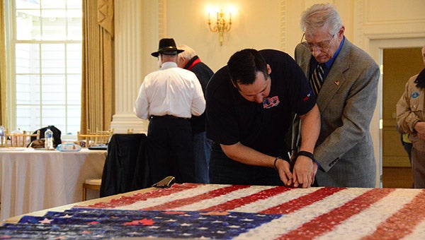 Don Goff, director of operations with the Flag for Hope project, helps place a new impression on the American Flag canvas when the team traveled to Montevallo’s American Village on Wednesday, Feb. 10. (Reporter Photo/Graham Brooks)