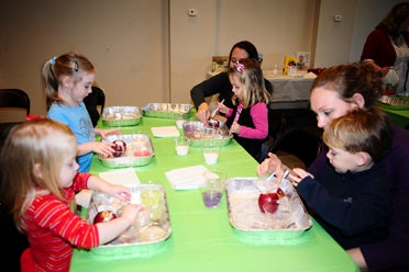 From left, Navi Jane Taylor, Laurel Taylor, Macy and Jill Crawford and Briggs and Rosie Kirchler mix baking soda and vinegar to create apple volcanoes. (Reporter Photo/Emily Sparacino)