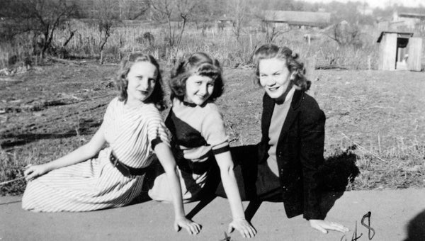"Who forgot to close the outhouse door?" This New Year's Day 1948 photograph shows three Helena belles celebrating the day by posing for photographs. From left are Clyte England, Margaret Clark and Lois England. In the upper right can be seen the old L&N freight house and the Lowery privy with open door. (Contributed/City of Helena Museum)