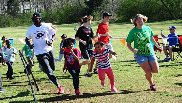 Members of the Thompson High School track team lead the first lap of the kindergarten fun run on March 17 at Creek View Elementary School. (Reporter Photo/Neal Wagner)