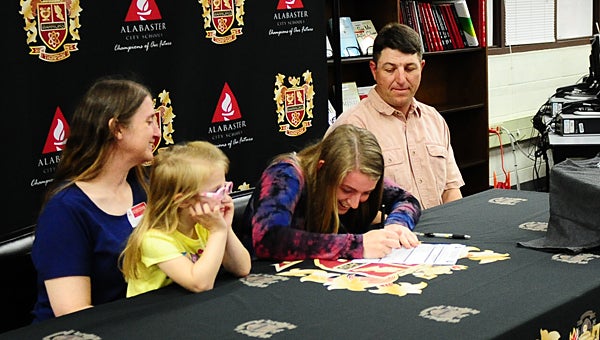 Thompson High School senior volleyball player Milea Ray signs an athletic scholarship during a March 23 ceremony while surrounded by her mother, Mandi, younger sister Brenna, and father, Cameron. (Reporter Photo/Neal Wagner)