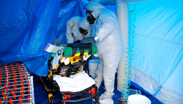 Doctors in Hazmat suits examine a patient, played by a Jeff State student, in a decontamination unit during a disaster response drill at Grandview Medical Center on April 14. (Reporter Photo/Molly Davidson)