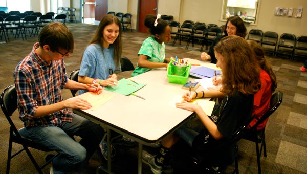 Members of the North Shelby Library Teen Leadership Council create posters for their upcoming potato stamp carving event during an April 28 meeting. (Reporter Photo/Molly Davidson)