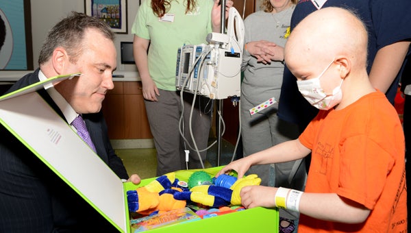 A patient at Children's of Alabama opens a "big green box of cheer" during a Cheeriodicals Day event April 6. The boxes were filled with activity books, room decorations and games for children to enjoy. (Contributed)
