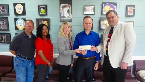 Shelby County District Court Judge Jim Kramer, far right, and incoming Juvenile Court Chief Probation Officer LeAnn Rigney, center, present a $4,800 check April 19 to Shelby County Arts Council Executive Director Bruce Andrews for a creative writing class at the juvenile detention center in Columbiana. (Reporter Photo/Emily Sparacino)