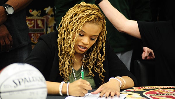 Thompson High School senior basketball player signs a scholarship to play at Shelton State Community College during an April 11 ceremony in the THS library. (Reporter Photo/Neal Wagner)