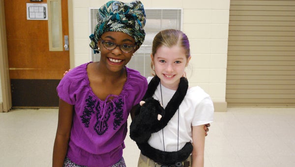 Brooklynn Manuel, as Maya Angelou, and Adlyn Flakenberry, as Jane Goodall, smile for a photo during the April 19 Living Wax Museum presentation at Inverness Elementary School. (Reporter Photo/Molly Davidson)
