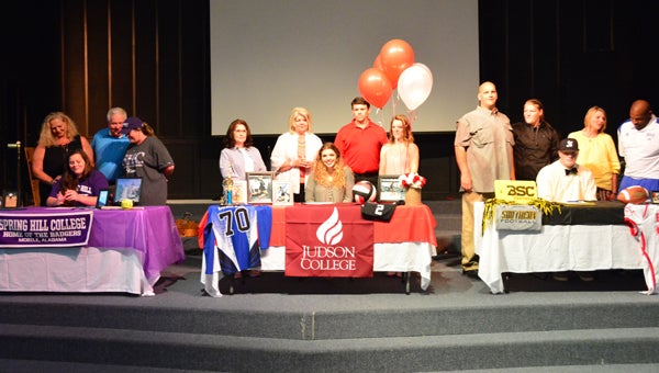 From left, Courtney Kendrick, Hannah Lumpkin and Corey Robinson pose on stage at Kingwood Christian School on April 5 as all three committed to furthering their athletic careers at the collegiate level. (Reporter Photo / Baker Ellis)