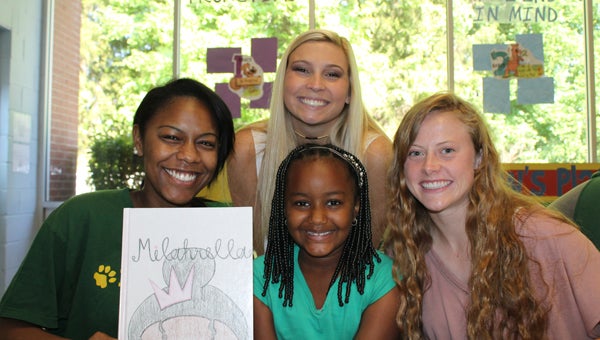 PHS seniors Danielle Sanders, Carsen Brasher and Jordan Allison are all grins after watching Milah enjoy the book they wrote for her. (Contributed)