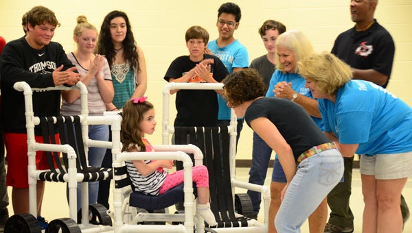 Lily Streets, center, sits in one of the aquatic wheelchair prototypes students in Thompson High School's Engineering Academy built for special-needs students. (Reporter Photo/Emily Sparacino)