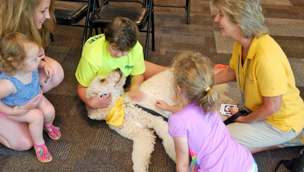 Hand in Paw therapy dog Simon gets love from kids during the North Shelby Library’s Homeschool Hangout on May 18. (Reporter Photo/Molly Davidson)