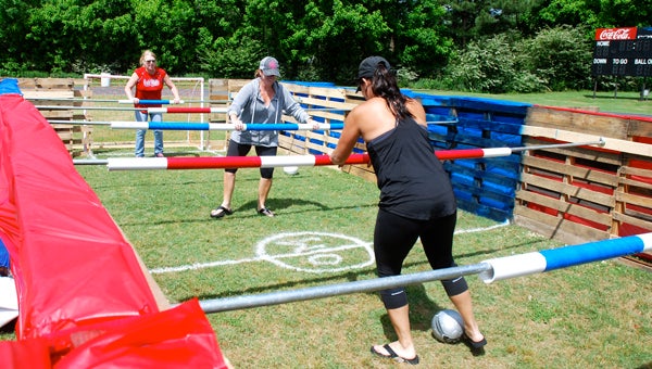 Parent volunteers test out the life-size foosball game. (Reporter Photo/Molly Davidson)