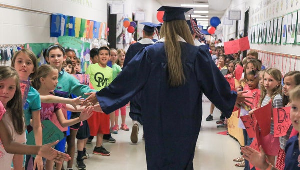 Oak Mountain Elementary School students high five an Oak Mountain High School senior as she walks through the OMES halls during the May 17 Grad Walk. (For the Reporter/Dawn Harrison)