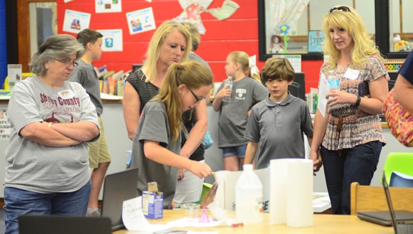 Elvin Hill Elementary fourth-grader Kaylee Veazey demonstrates how a volcano erupts as she tells parent visitors about her research on the destruction of Pompeii at the school's first Leadership Day on May 6. (Reporter Photo/Emily Sparacino)