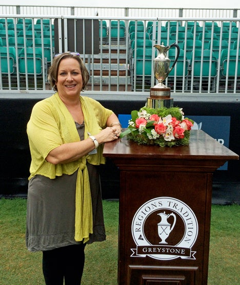 Lesa Nivens, owner of Gail's Florist in Columbiana, stands next to the trophy stand at the recent Regions Traditions golf tournament at Greystone.  Nivens is the florist of choice for the PGA Tour. (Contributed)