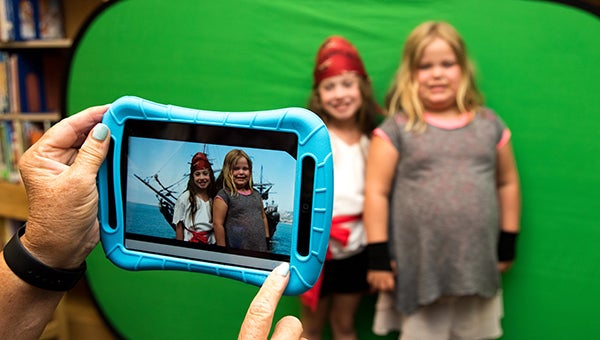 From left, Kyndall Payton and Libby Shackelford stand in front of a green screen to make a portion of their film at the creation station summer enrichment camp at Helena Elementary School the week of June 20. (Reporter Photo/Keith McCoy)