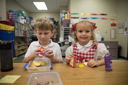 Kindergarteners Cade Underwood and Coline Hemphill takes a snack break on the first day of school.