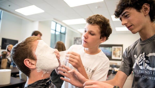 Westminster School at Oak Mountain 10th graders John Porterfield, left, sits still while classmates Cooper Reynolds, center, and Daniel Harry use plaster to make a mask as part of a project that help students learn about Egyptian culture. (Photos by Keith McCoy)