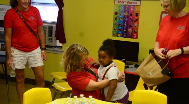 Taniya Hudson hugs one of her teachers from Creek View Elementary School. (Reporter photo/Alec Etheredge)