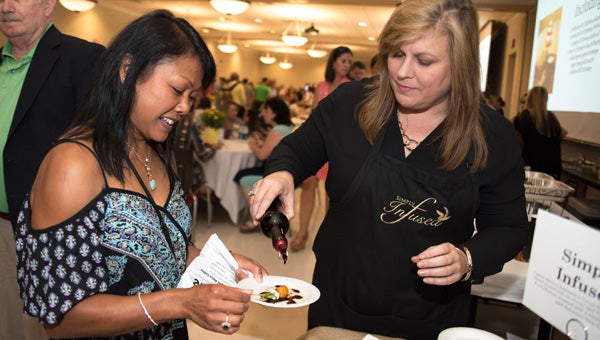 Cherl Harper, right, of Simply Infused serves Ann Handley their traditional balsamic vinegar during Taste of Shelby County on Sept. 8 at Jefferson State Community College Shelby-Hoover Campus. (Photo by Keith McCoy)