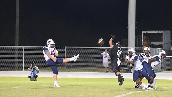 Helena's Nash Adams (10) blocks a Homewood punt in the third quarter to help spark a win for Helena on Friday, Sept. 16. (For the Reporter/Brian Vansant)