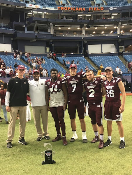 Logan Burnett poses with all of the Mississippi State quarterbacks and Coach Johnson. (Contributed)